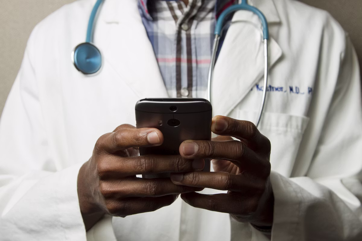 Doctor working on a laptop with a stethoscope beside it